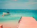 Beautiful blue crystal clear beach. Fishing boat pier