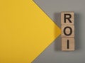 ROI, return of investment text on wood cubes on banner with copy space