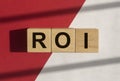 ROI, return of investment text on wood cubes