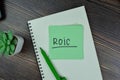 ROIC - Return on Invested Capital write on sticky notes isolated on Wooden Table