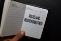 Roles and Responsibilites! write on notebook isolated on black background