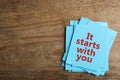 Roles and responsibilities concept. Blue paper cards with phrase It stars with you and space for text on wooden table, top view Royalty Free Stock Photo