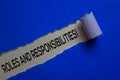 Roles And Responsibilities! Text written in torn paper