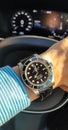 Rolex Submariner no date model on wrist in Volvo car