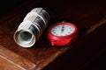 A roll of 100 american dollar banknotes with red clock stopwatch on wooden drawer on dark moody black backgroun Royalty Free Stock Photo