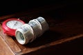 A roll of 100 american dollar banknotes with red clock stopwatch on wooden drawer on dark moody black background Royalty Free Stock Photo