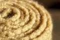 Roll of beige pattern stitch knitted woolen background
