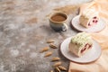 Roll biscuit cake with cream cheese and jam, cup of coffee on brown concrete, side view, copy space Royalty Free Stock Photo