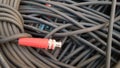 A roll of black cable closeup with a red plug Royalty Free Stock Photo