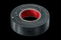 Black duct tape roll on a dark background, showcasing its texture and design in clear detail for practical uses Royalty Free Stock Photo