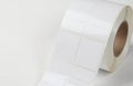 Roll of blank white rectangular adhesive label stickers. Ideal for printing, packaging, organizing items, shipping logistics. Royalty Free Stock Photo