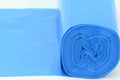 A roll of blue plastic trash bags, lightly rolled out on a horizontal surface Royalty Free Stock Photo