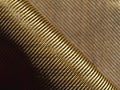 Roll of bulletproof material aramid. Shining aramid kevlar background. Bronze kevlar texture and pattern Royalty Free Stock Photo