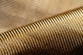 Roll of bulletproof material aramid. Shining aramid kevlar background. Bronze kevlar texture and pattern Royalty Free Stock Photo