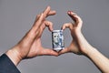 A Roll of dollars with the heart made of two hands. love money concept Royalty Free Stock Photo