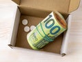 Roll of 100 euro banknotes and few pills in an open small cardboard box. Saving money for health care and treatment, planning for Royalty Free Stock Photo