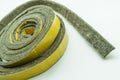 A roll of felt insulation. Self-adhesive tape with felt insulation for entrance doors. Goods for repair. Selective focus