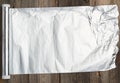 Roll of gray foil for baking and packaging food on a wooden background Royalty Free Stock Photo