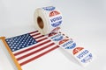 Roll of I Voted Today stickers and american flag on white background. US presidential election concept Royalty Free Stock Photo