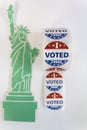 Roll of I Voted Today stickers and statue of liberty on white background. US presidential election concept Royalty Free Stock Photo