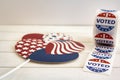 Roll of I Voted Today stickers and USA balloons on white wooden table. US presidential election concept