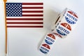 Roll of I Voted Today stickers and USA flag on white background. US presidential election concept Royalty Free Stock Photo