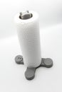 Roll of kitchen paper towel standing on grey plastic holder Royalty Free Stock Photo