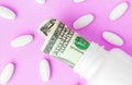 Roll of money Bills in white pill bottle with white pills. The High Cost of Health Care. Pills and US Currency in Pill Bottles Royalty Free Stock Photo