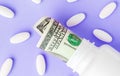 Roll of money Bills in white pill bottle with white pills. The High Cost of Health Care. Pills and US Currency in Pill Bottles Royalty Free Stock Photo