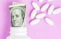 Roll of money Bills in white pill bottle with white pills. The High Cost of Health Care. Pills and US Currency in Pill Bottles Royalty Free Stock Photo