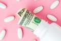 Roll of money Bills in white pill bottle with white pills. The High Cost of Health Care. Pills and US Currency in Pill Bottles Royalty Free Stock Photo