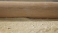 Roll out pizza base dough with a rolling pin.