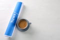 Roll of papers with word NEWS and cup of coffee on wooden table Royalty Free Stock Photo