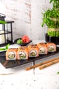 Roll Philadelphia made of Fresh Salmon, Cream Cheese, smoked eel, avocado and cucumber inside. Royalty Free Stock Photo