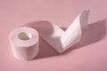 A roll of pink toilet paper on a pink background Royalty Free Stock Photo