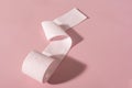 A roll of pink toilet paper on a pink background