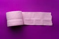 Roll of pink toilet paper on a purple background Royalty Free Stock Photo