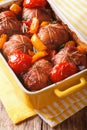 Roll of rabbit baked with tomato and pepper in baking dish. Vert