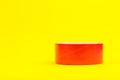 A roll of red duct tape isolated on a yellow background Royalty Free Stock Photo