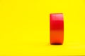 A roll of red duct tape isolated on a yellow background Royalty Free Stock Photo