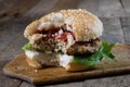 Roll with roast cutlet. Hamburger on a wooden board. Kitchen tab