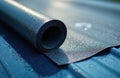 Roll roofing material rests on a metal surface. Bituminous waterproofing membrane texture. Construction and building concept. Royalty Free Stock Photo