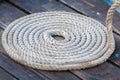 Roll of rough mooring rope on wooden dock Royalty Free Stock Photo