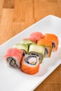 Roll with salmon, tuna, avocado and shrimp on a white plate. close up Royalty Free Stock Photo