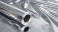A roll of shiny aluminum foil rests on a crumpled silver surface. The metallic texture reflects light, creating a sleek Royalty Free Stock Photo