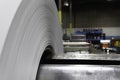 Roll of Steel on factory decoiler machine. used to make roofing sheets. Metal roll being uncoiled Royalty Free Stock Photo