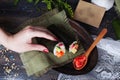 Roll sushi black different tastes, hands, tray, dish crab, carrots, lettuce, tofu, salmon, still life, home, stylish, wooden Royalty Free Stock Photo