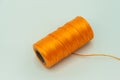 A roll of synthetic orange thread