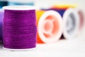 The roll of thread put at the left side on background,purple color,needlework,craft,sewing and tailoring concept