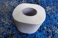 A roll of toilet paper on a blue background. Top view Royalty Free Stock Photo